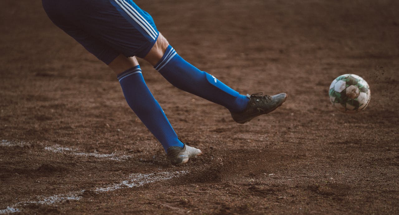 action-shot-of-soccer-player-kicking-ball-on-field-30754777